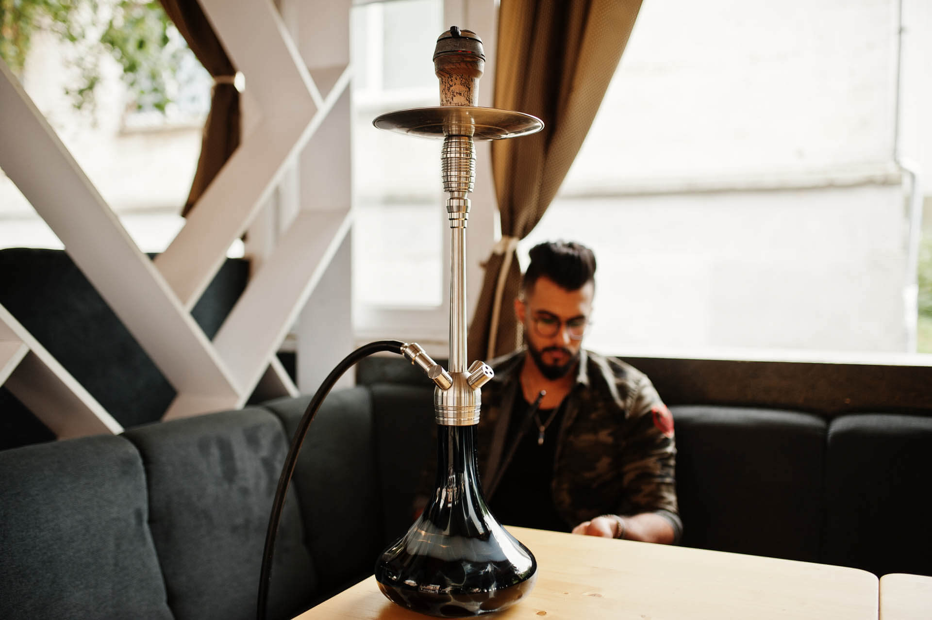 Mann in Shisha Bar im Winter, dem die Shisha vielleicht nicht schmeckt